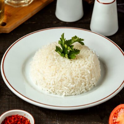 side view of a plate with cooked rice with parsley on the table side view of a plate with cooked rice with parsley on the table