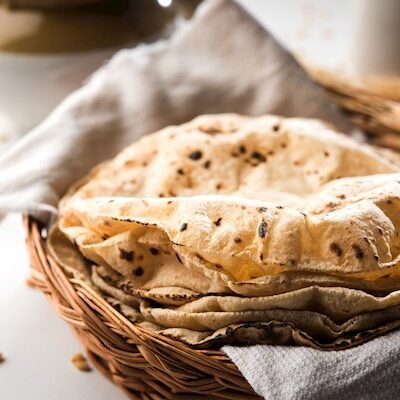 Phulka Indian Chapati / Fulka or Gehu Roti with wheat grains in background. It's a Healthy fiber rich traditional North/South Indian food, selective focus