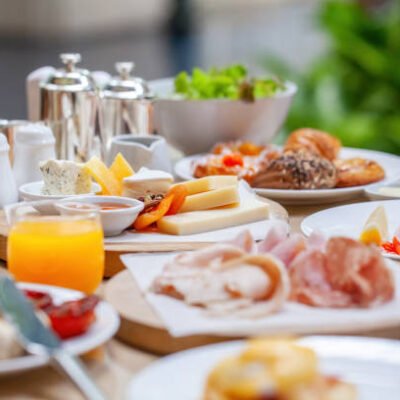 American breakfast Table full of various fresh food in luxury modern restaurant. Delicious dishes, cold cuts, salmon, omelette, pastries, juices, cheese. Delicious and lavish breakfast or morning meal in high-end hotel
